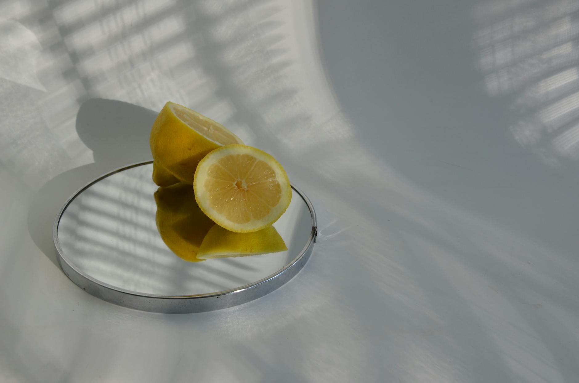 A close-up view of a hand holding a blue vibrator above a decorative glass bowl.