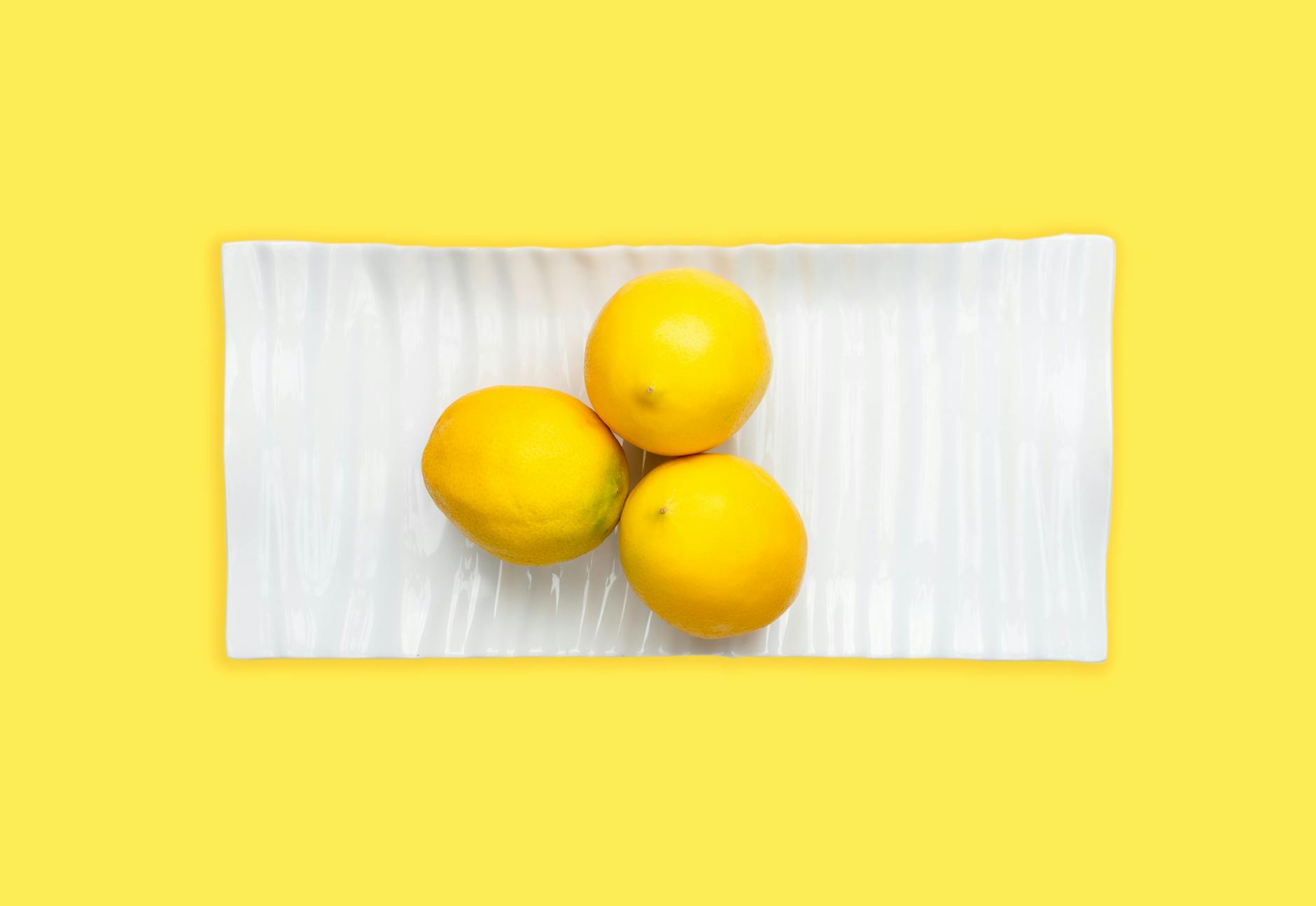 Fresh lemons arranged on a white plate, symbolizing the natural pleasure and simplicity of choosing the right vibrator
