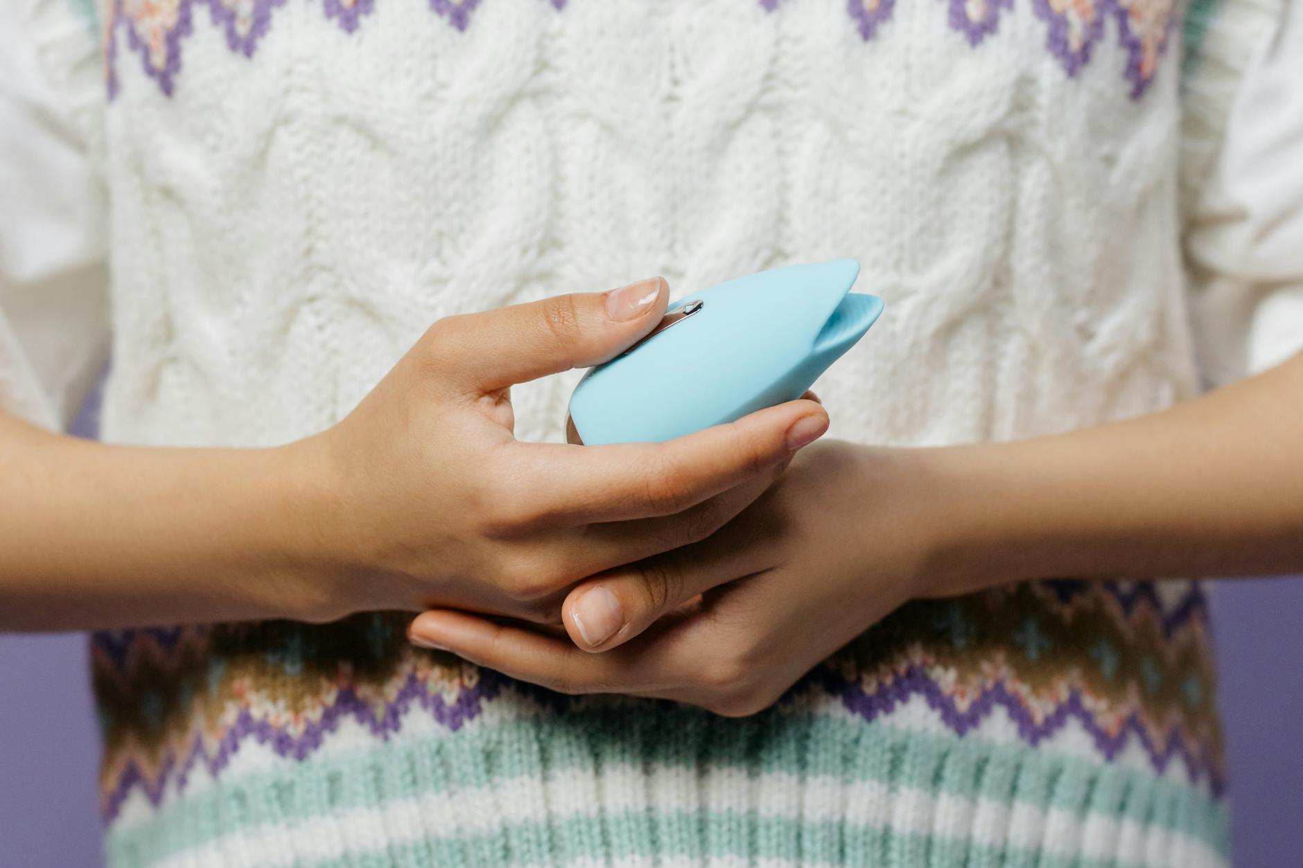 A young couple standing together indoors, holding a blue vibrator, symbolizing modern intimacy and shared exploration.